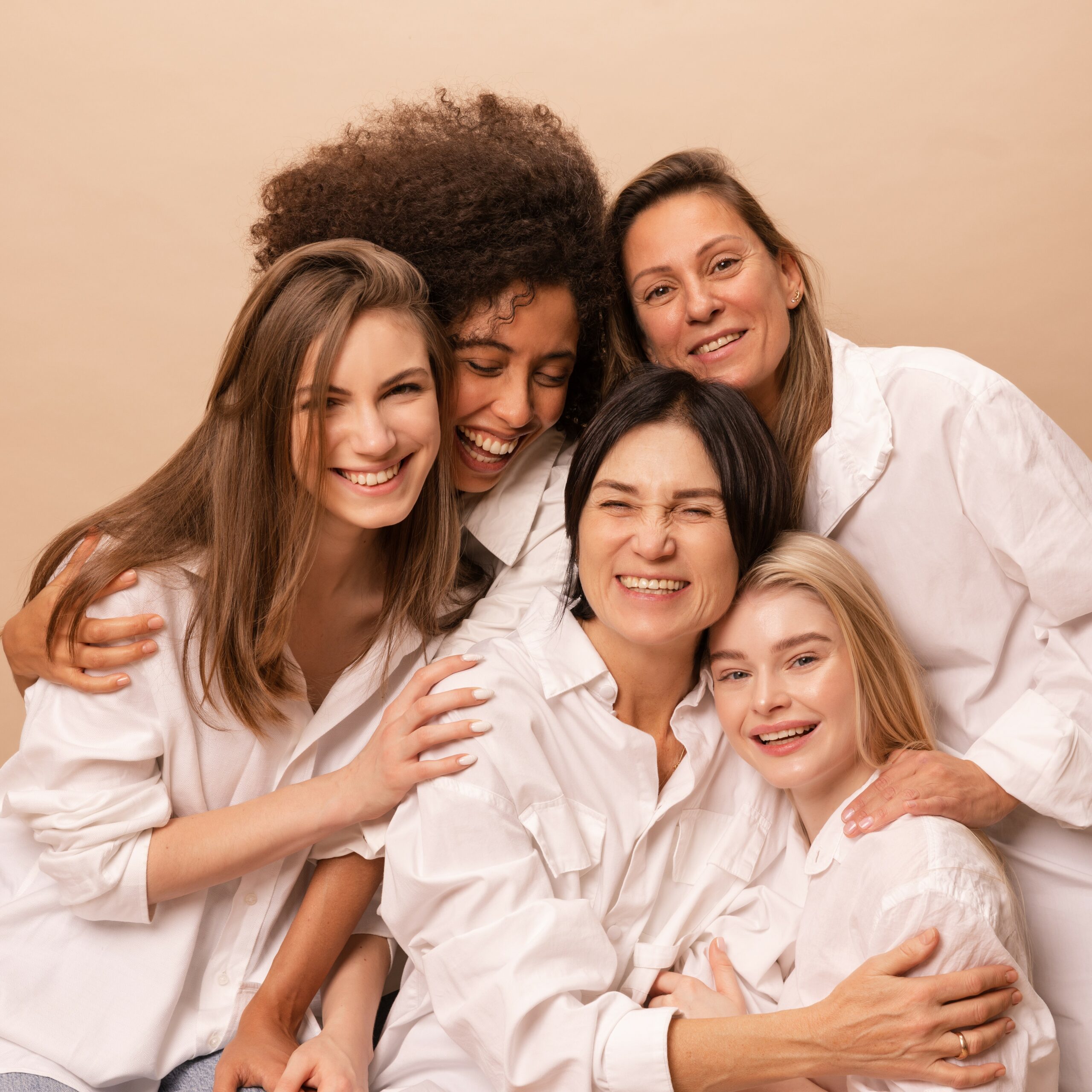 Accueil BERSON 5 joyful caucasian african women different ages white shirts laughing looking camera beige background 1 scaled